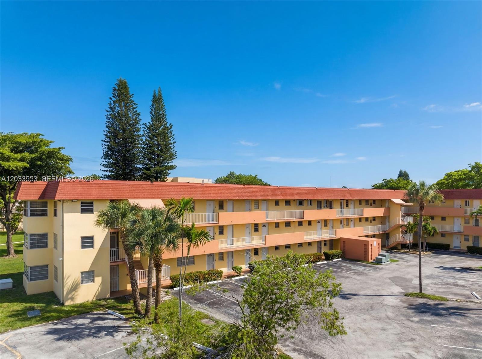 A three-story apartment building with a red tile roof and exterior walkways — 1540 NE 191st St # 145, Miami FL 33179, MIAMI, FL