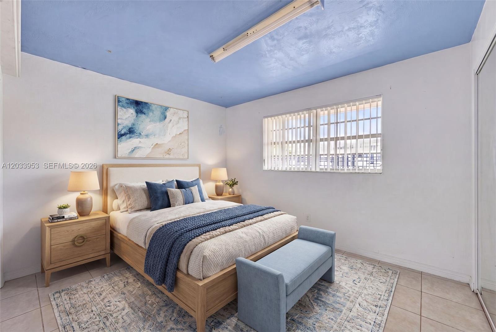 A bedroom features a blue ceiling, a wooden bed frame, and a light-colored area rug — 1540 NE 191st St # 145, Miami FL 33179, MIAMI, FL
