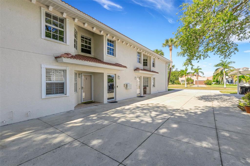 A two-story stucco building with a concrete driveway and palm trees under a blue sky — 528 W VENICE AVENUE UNIT # 1, VENICE, FL