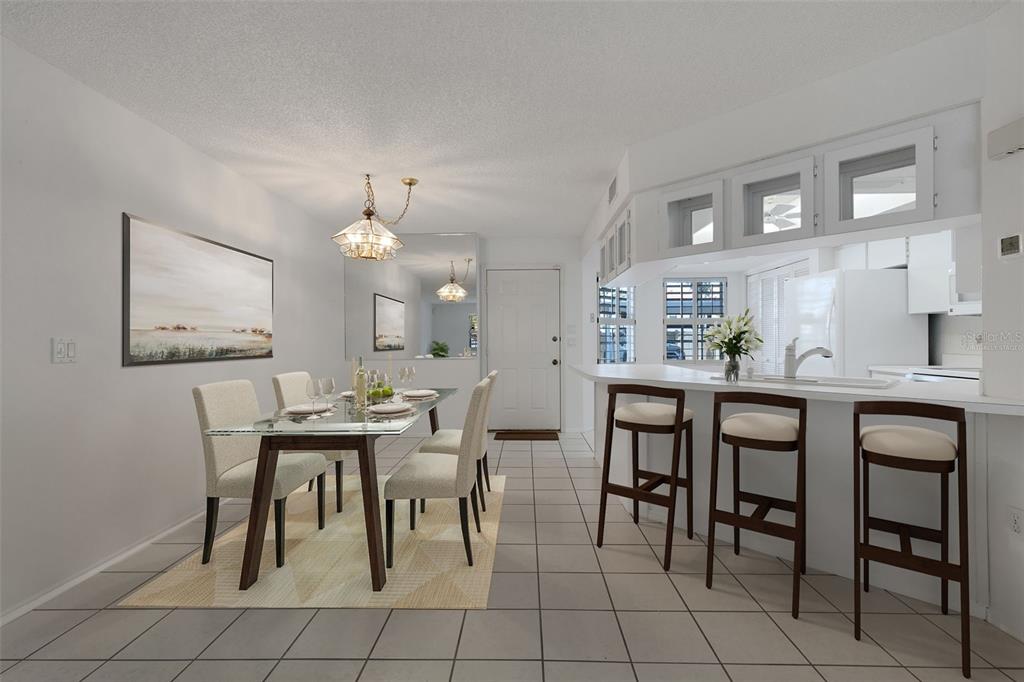 A dining area with a glass table and a kitchen with a breakfast bar — 528 W VENICE AVENUE UNIT # 1, VENICE, FL