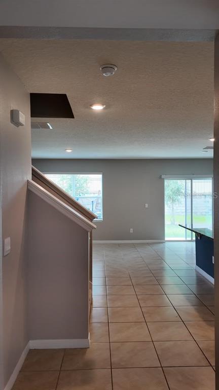 A view from a hallway looking into an open-concept living area with tile flooring — 11237 AMBER RIDGE DRIVE, ZELLWOOD, FL