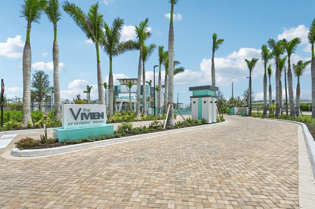 The entrance to The Vivien apartment homes features a paved driveway and palm trees — 3901 Coast View Pointe # C2, Vero Beach FL 32960, VERO BEACH, FL