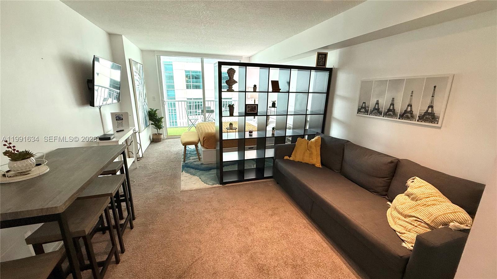This studio apartment features a living area, dining space, and a bedroom separated by shelving — 1200 Brickell Bay Dr # 2216, Miami FL 33131, MIAMI, FL