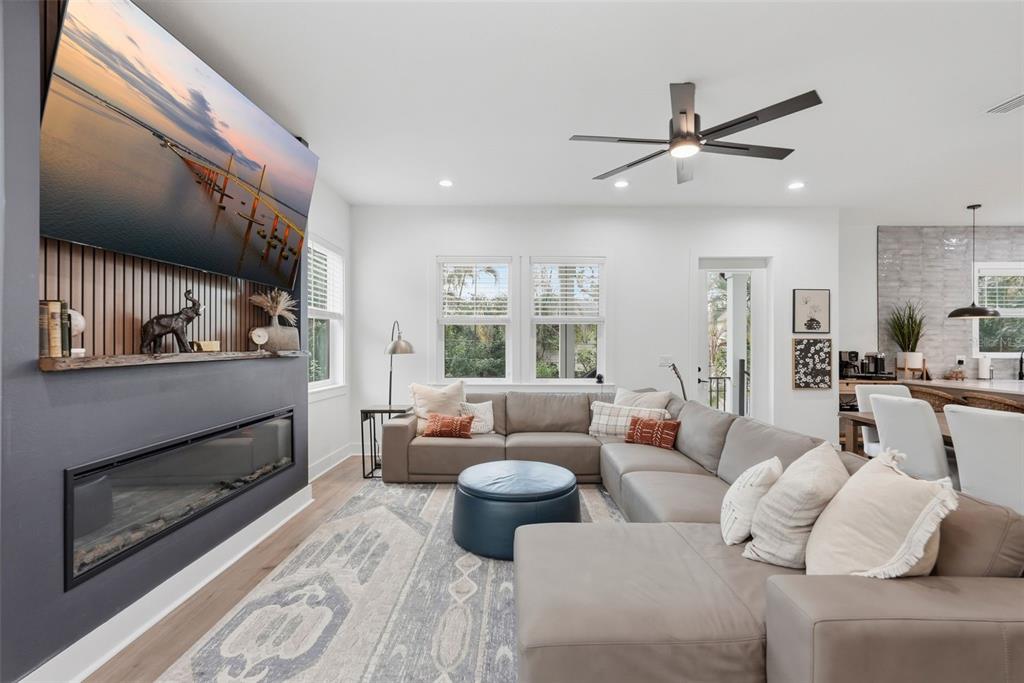 A living room features a gray sectional sofa, a fireplace, and a wall-mounted television — 1727 MARYLAND AVENUE NE, ST PETERSBURG, FL