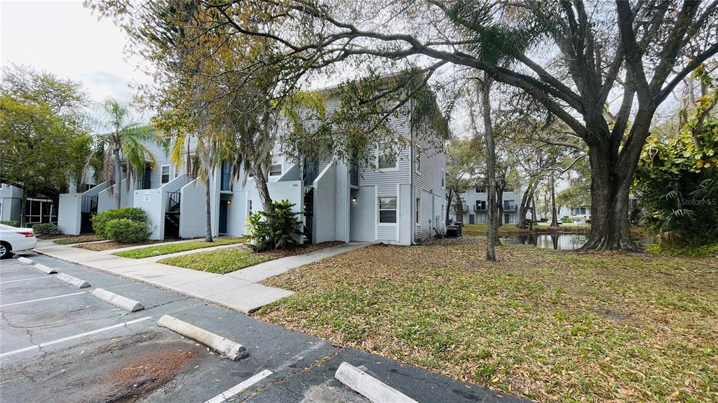 An interior view of a room with tiled floors, a pass-through window, and a window — 7120 WATERSIDE DRIVE UNIT 106, TAMPA, FL