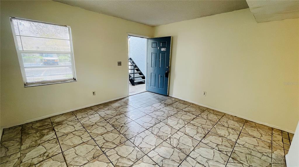 A galley kitchen features white appliances, wood cabinets, and light-colored tile flooring — 7120 WATERSIDE DRIVE UNIT 106, TAMPA, FL