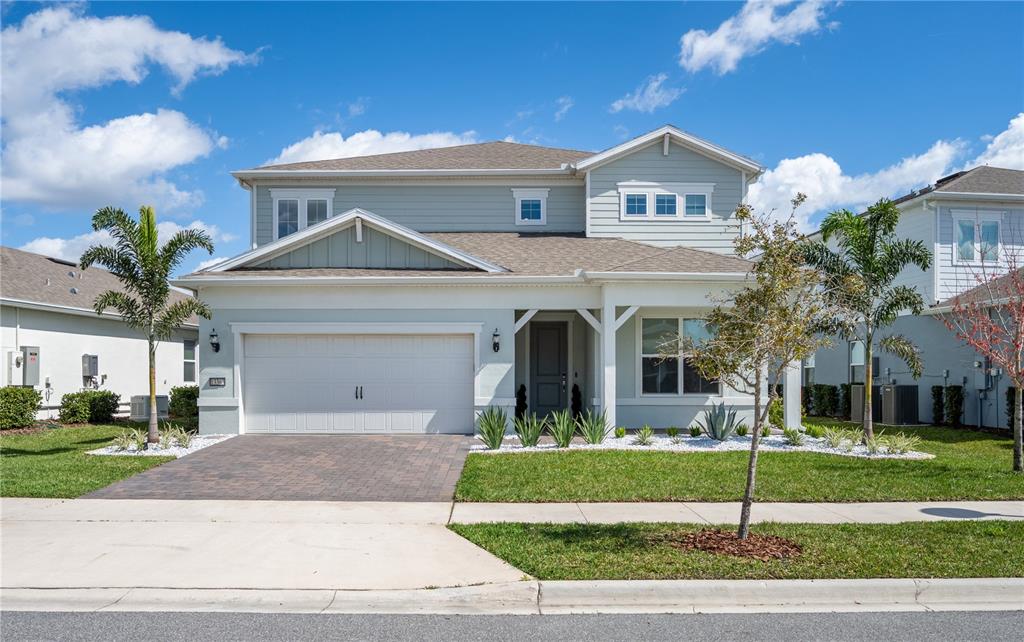 A two-story suburban house with a light blue exterior, a two-car garage, and a paved driveway — 13363 PANAMA BEACH COURT, ORLANDO, FL
