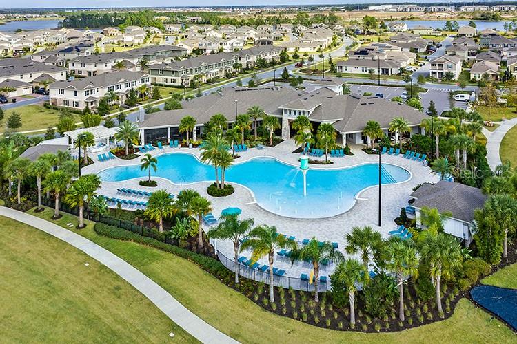 An aerial view shows a community swimming pool surrounded by lounge chairs and palm trees — 12026 SHINE VIEW LANE, WINTER GARDEN, FL