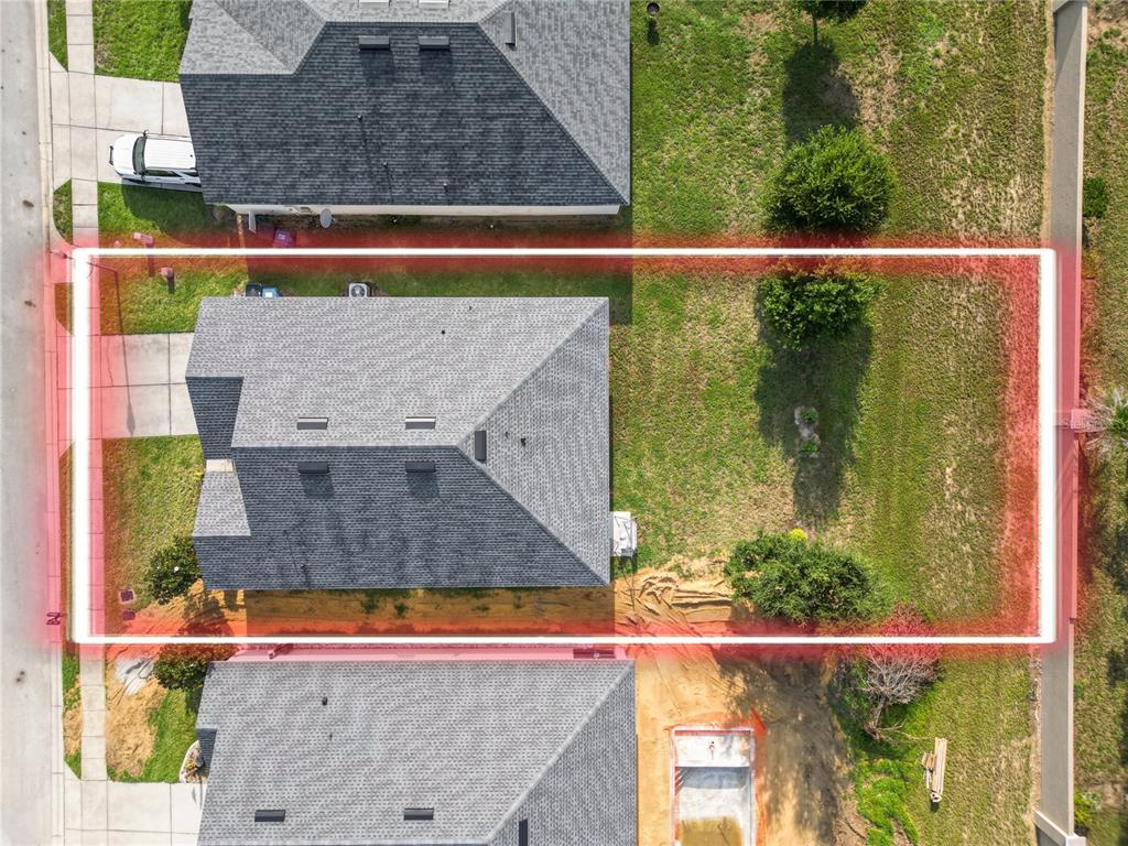 An aerial view shows a residential house with a large backyard highlighted in red — 813 SHEEN CIRCLE, HAINES CITY, FL