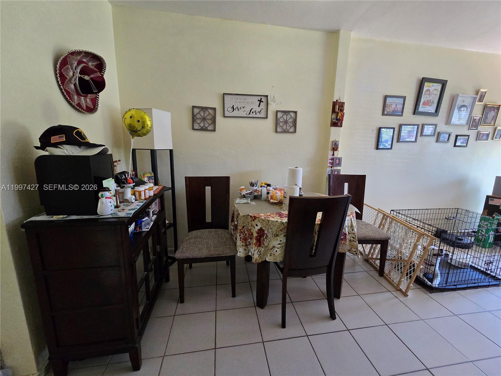 A dining area features a small round table, three chairs, a dark cabinet, and tiled floors — 820 SW 11th Ave # 5B, Hallandale Beach FL 33009, HALLANDALE BEACH, FL