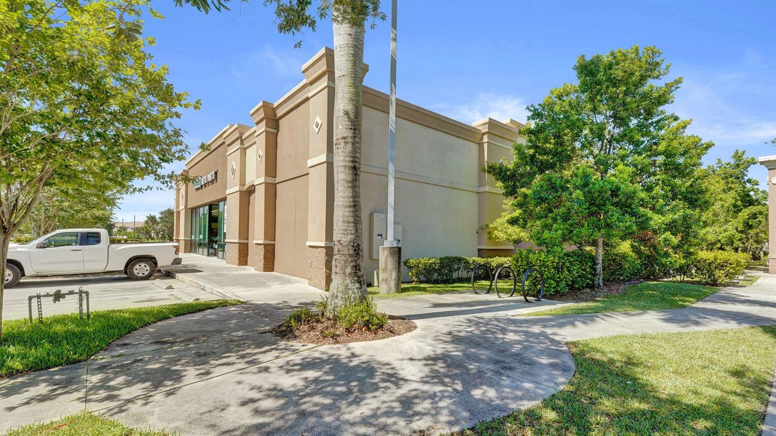 A white pickup truck is parked in front of a tan commercial building with landscaping — 4100 N University Drive, Cooper City FL 33024, COOPER CITY, FL