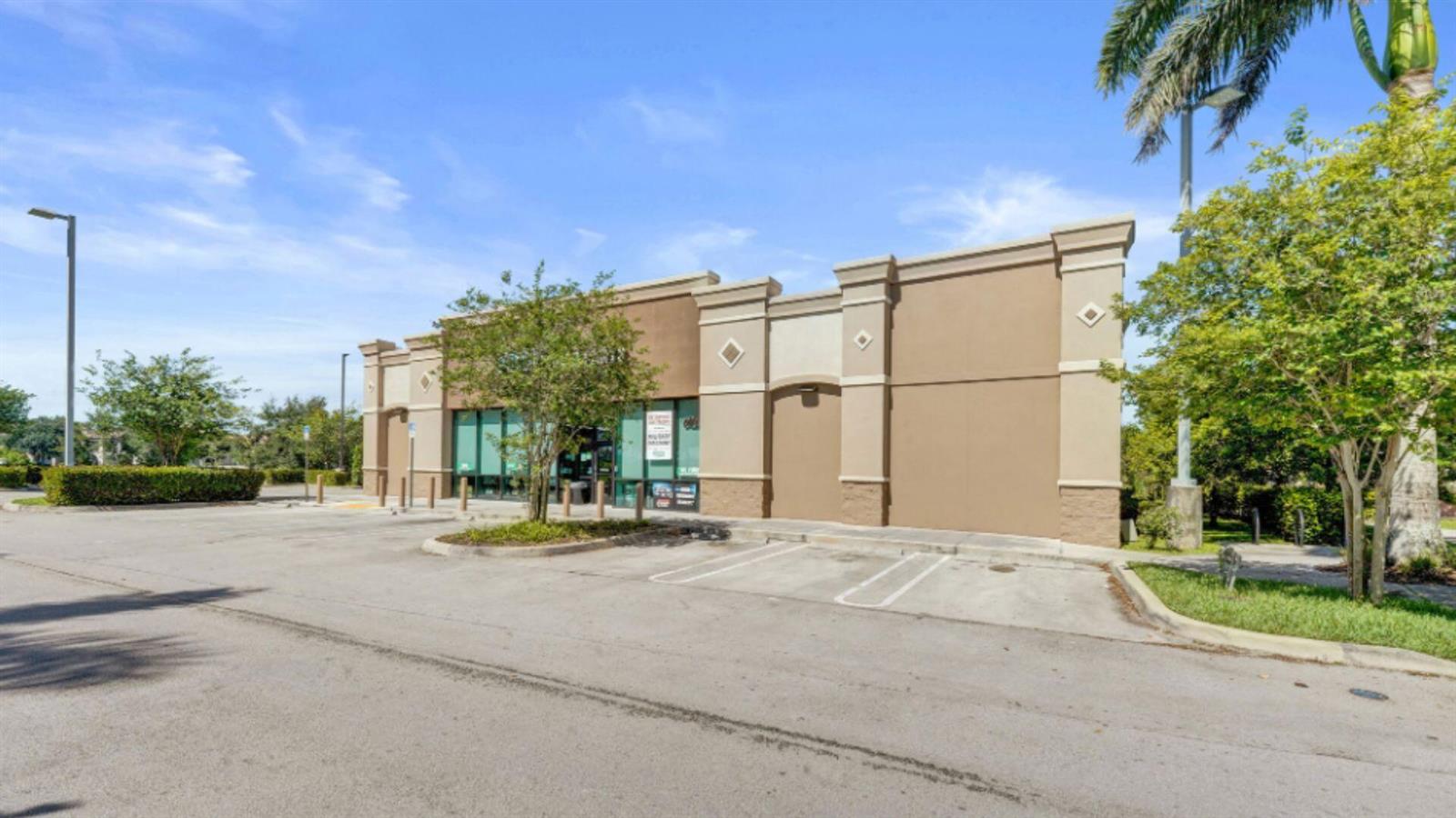 A single-story commercial building with a tan stucco exterior and a parking lot in front — 4100 N University Drive, Cooper City FL 33024, COOPER CITY, FL