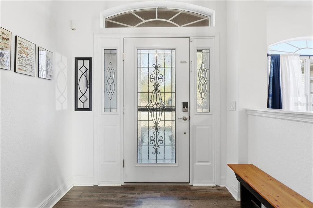 An entryway features a white front door with decorative glass panels and a transom window — 21 LOBELIA COURT, HOMOSASSA, FL