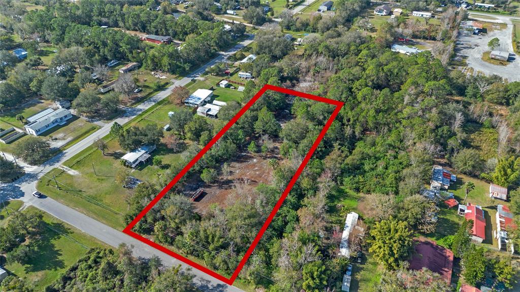 An aerial view shows a rectangular vacant lot outlined in red surrounded by trees — 1520 8TH STREET, ORLANDO, FL