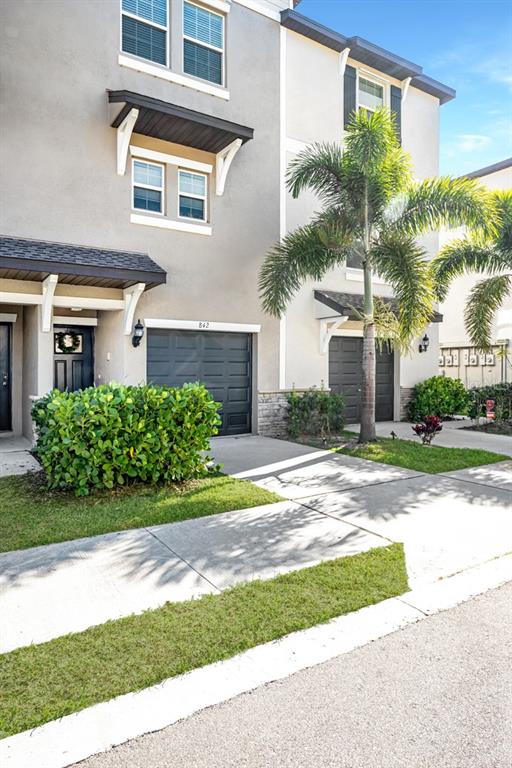 A kitchen with white cabinets, stainless steel appliances, a granite island, and two bar stools — 842 TENNYSON MILL CIRCLE, TAMPA, FL