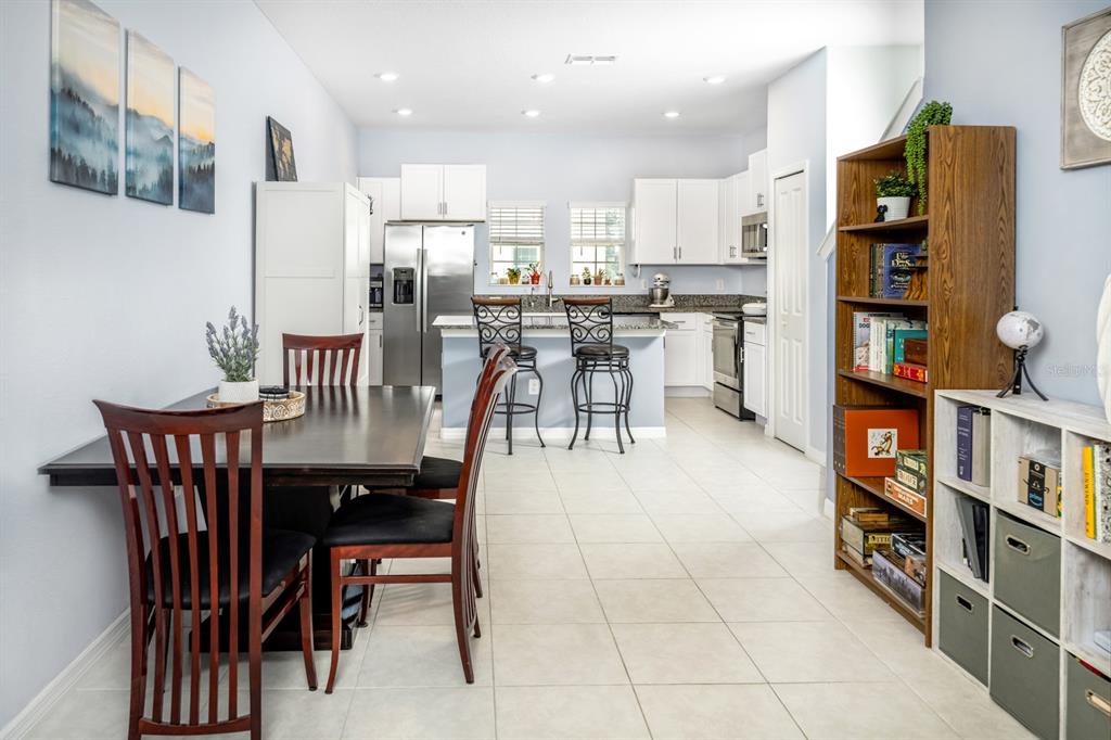 A kitchen features white cabinets, granite countertops, stainless steel appliances, and a breakfast bar — 842 TENNYSON MILL CIRCLE, TAMPA, FL