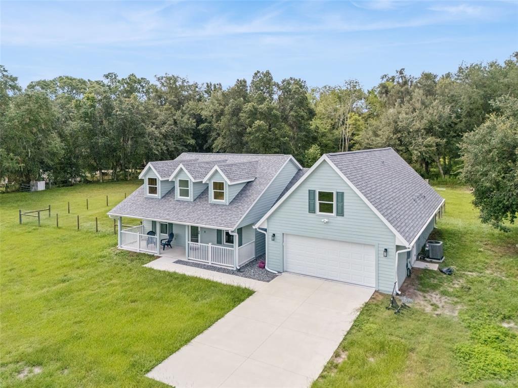 An aerial view of a light blue house with a white garage and front porch — 967 CR 753S, WEBSTER, FL