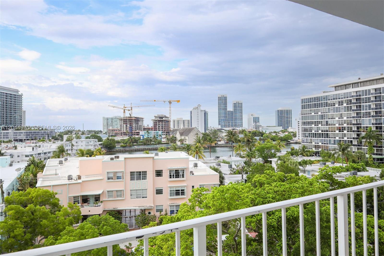 A balcony view overlooks a city skyline, a waterway, and surrounding residential buildings — 6900 Bay Dr # 6H, Miami Beach FL 33141, MIAMI BEACH, FL