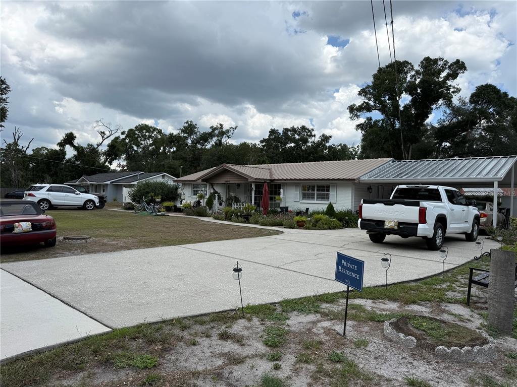 A single-story house with a metal roof, a carport, and a concrete driveway — 5408 EUREKA SPRINGS ROAD, TAMPA, FL