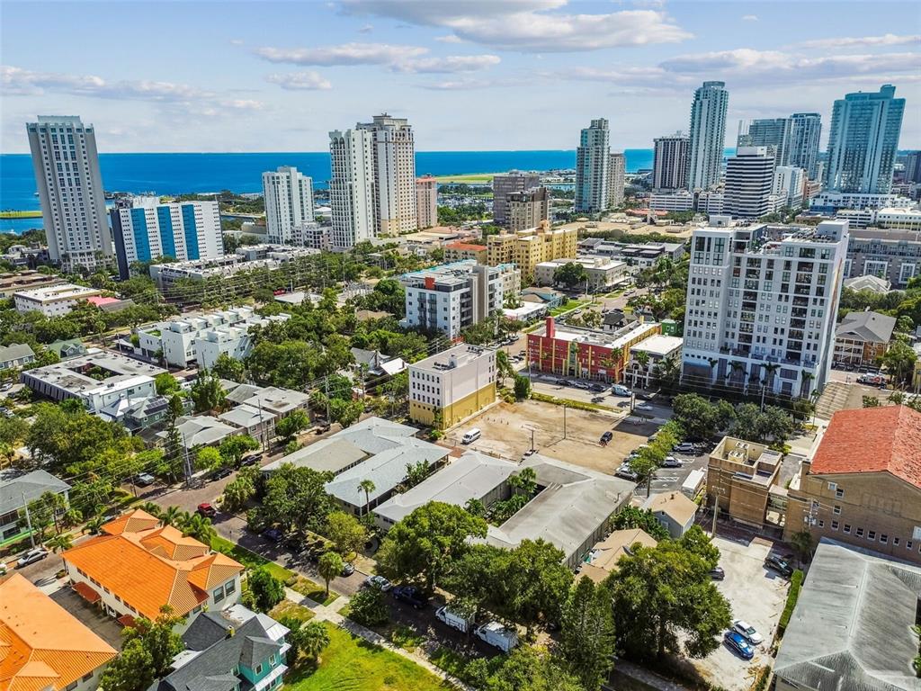 An aerial view of a city skyline with high-rise buildings, trees, and a vacant lot — 210 6TH AVENUE N UNIT 9, ST PETERSBURG, FL