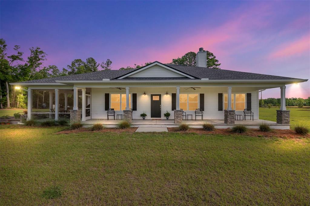 A red metal barn with a covered open bay and white-trimmed windows sits outdoors — 3725 172ND STREET, WELLBORN, FL