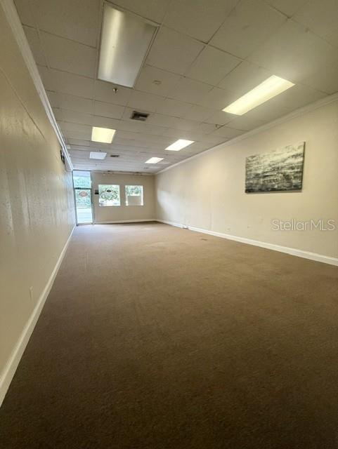 An empty commercial space features beige carpeting, white walls, and a drop ceiling with recessed lighting — 54 E MAIN STREET, APOPKA, FL