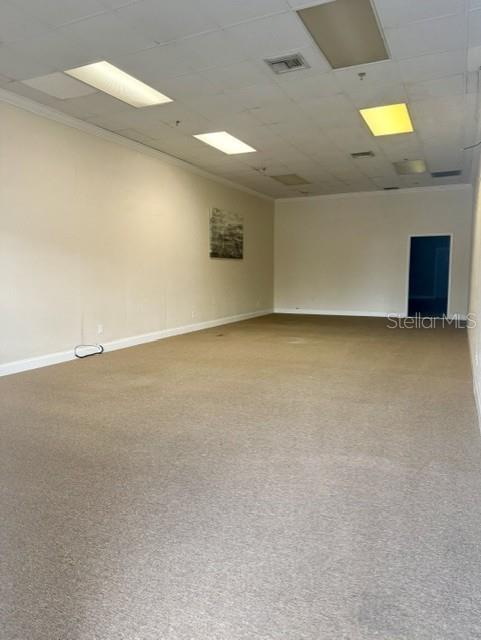 An empty commercial space features beige carpeting, off-white walls, and a drop ceiling with lights — 54 E MAIN STREET, APOPKA, FL