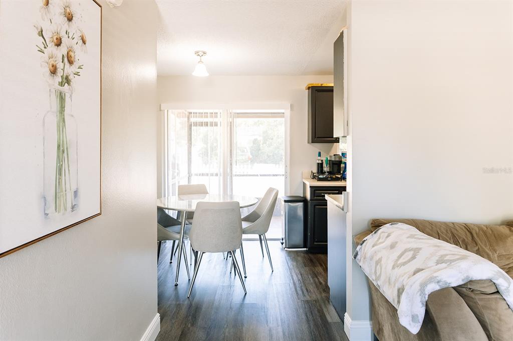 A dining area with a glass table and chairs sits next to a kitchen corner — 14115 VILLAGE VIEW DRIVE, TAMPA, FL