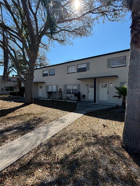 A two-story apartment building with a concrete walkway and large trees in the front yard — 11916 133RD AVENUE, LARGO, FL