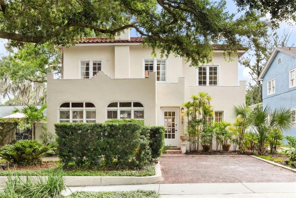 A two-story stucco house with a red tile roof, arched windows, and a brick driveway — 318 VITORIA AVENUE, WINTER PARK, FL