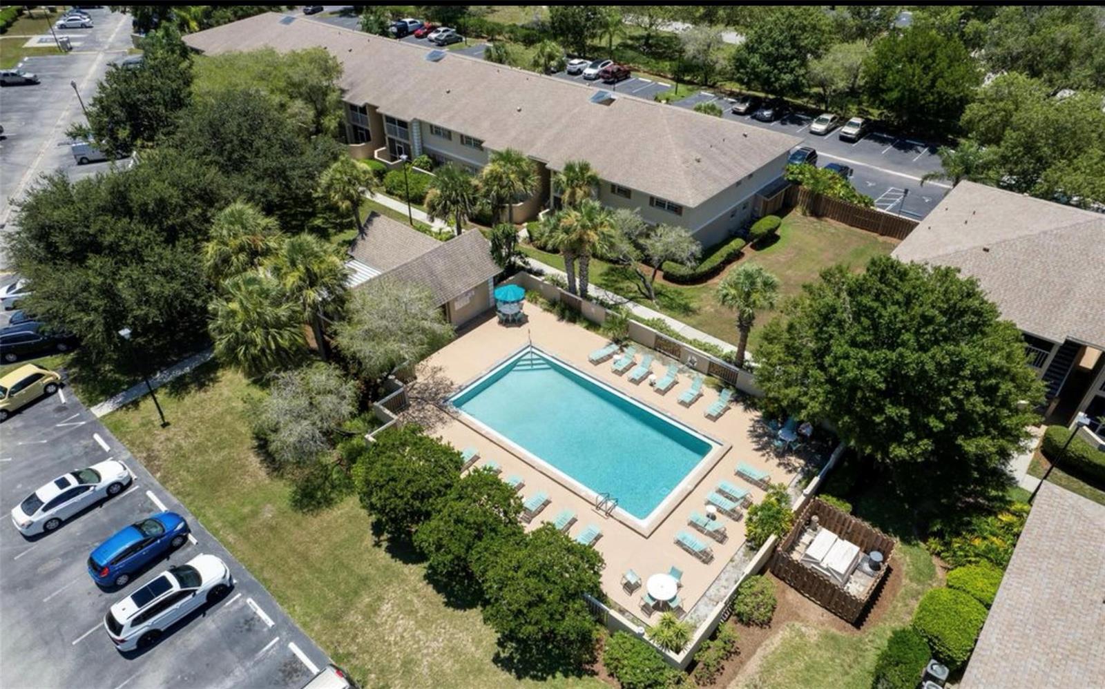 An aerial view of an apartment complex featuring a rectangular swimming pool and parking lot — 1640 NE Sunny Brook Lane # a203, Palm Bay FL 32905, PALM BAY, FL