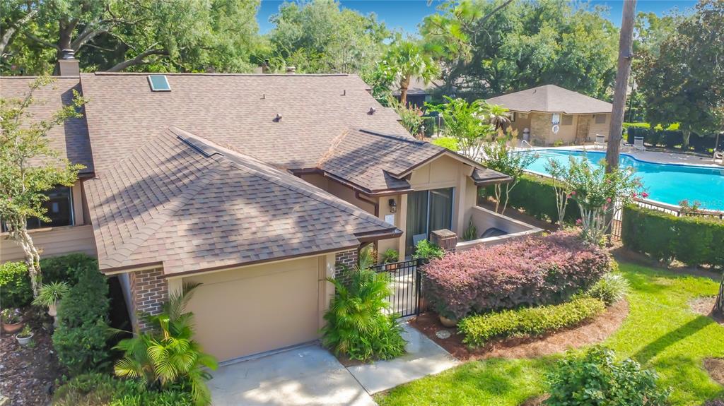 An aerial view of a single-story house with a garage, patio, and adjacent swimming pool — 456 NEWTON PLACE, LONGWOOD, FL