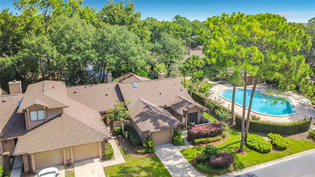 An aerial view of a suburban house with a brown roof and a swimming pool — 456 NEWTON PLACE, LONGWOOD, FL