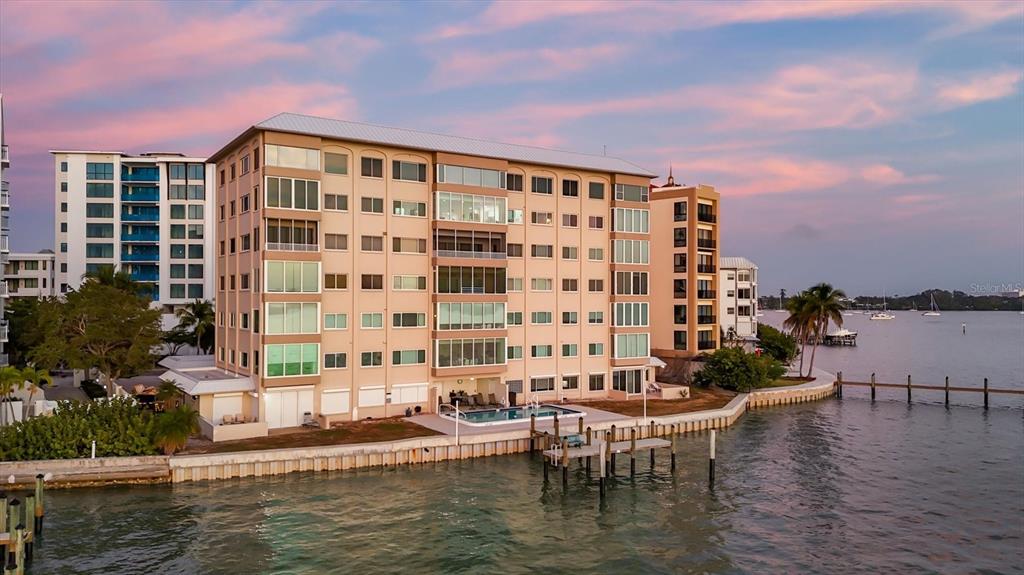 An aerial view of a waterfront apartment building with a pool and a private dock — 350 GOLDEN GATE POINT UNIT 62, SARASOTA, FL