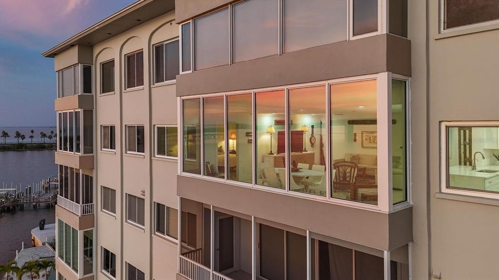 An exterior view of a multi-story building with large glass windows overlooking a waterfront — 350 GOLDEN GATE POINT UNIT 62, SARASOTA, FL