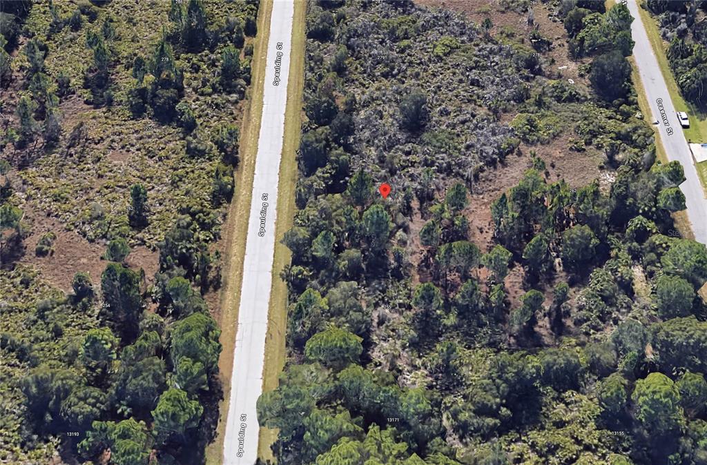 This is an aerial map view of a wooded, undeveloped lot located between two streets — 263 SPAULDING STREET, PORT CHARLOTTE, FL