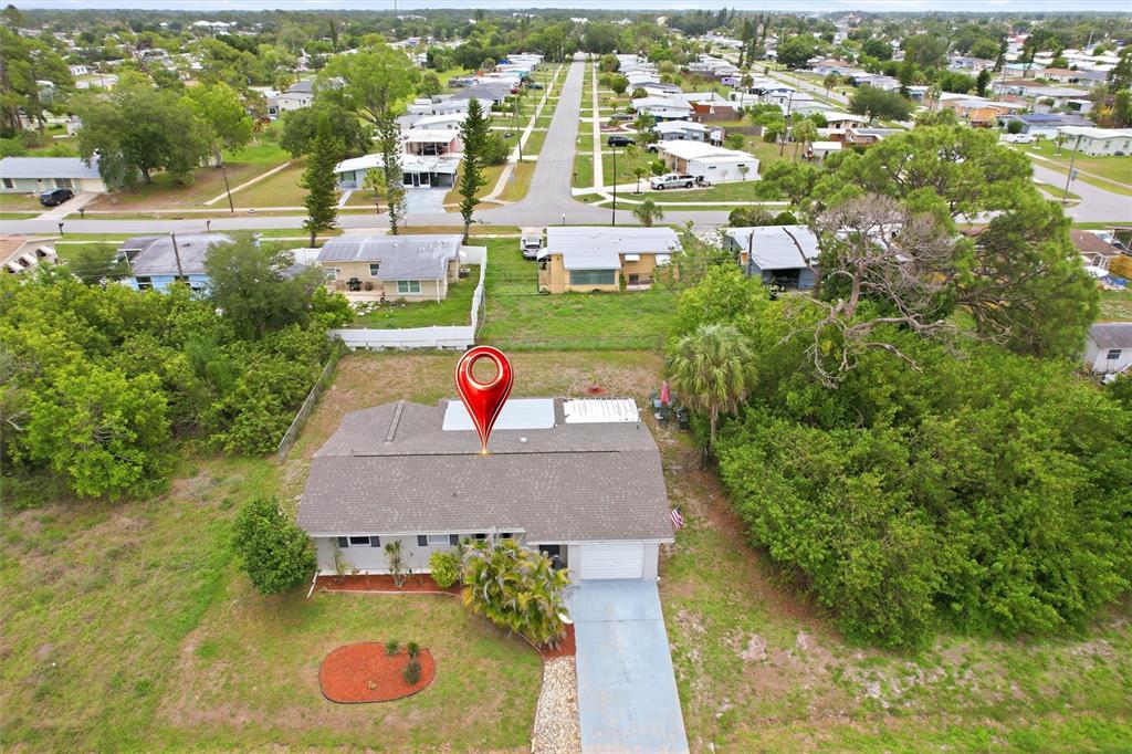 An aerial view shows a single-story house with a gray roof and a driveway — 213 GRANADA BOULEVARD, NORTH PORT, FL