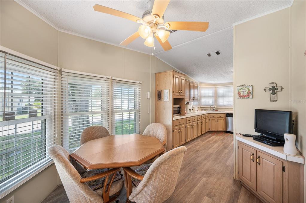 A dining area with a wooden table and chairs sits adjacent to a kitchen — 1610 REYNOLDS ROAD UNIT 333, LAKELAND, FL