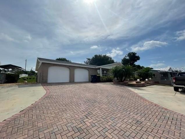 A brick house with a two-car garage and a herringbone-patterned paver driveway — 1326 LAKE ARIANA BOULEVARD, AUBURNDALE, FL
