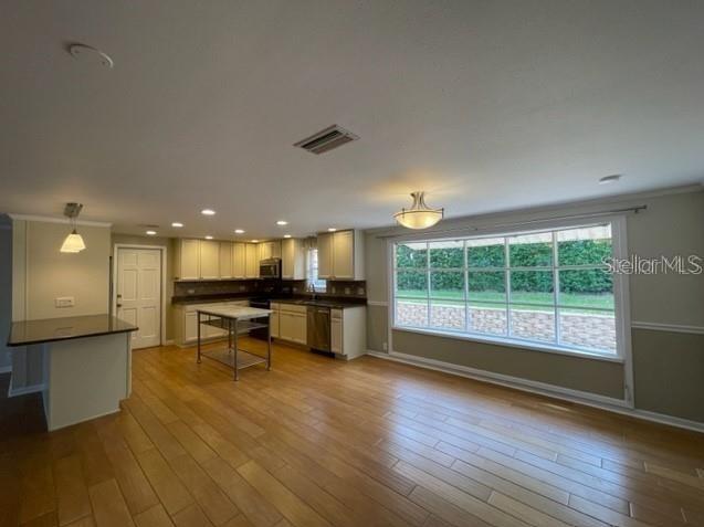 A kitchen with light-colored cabinets, a metal island, and a large window overlooking a yard — 1326 LAKE ARIANA BOULEVARD, AUBURNDALE, FL