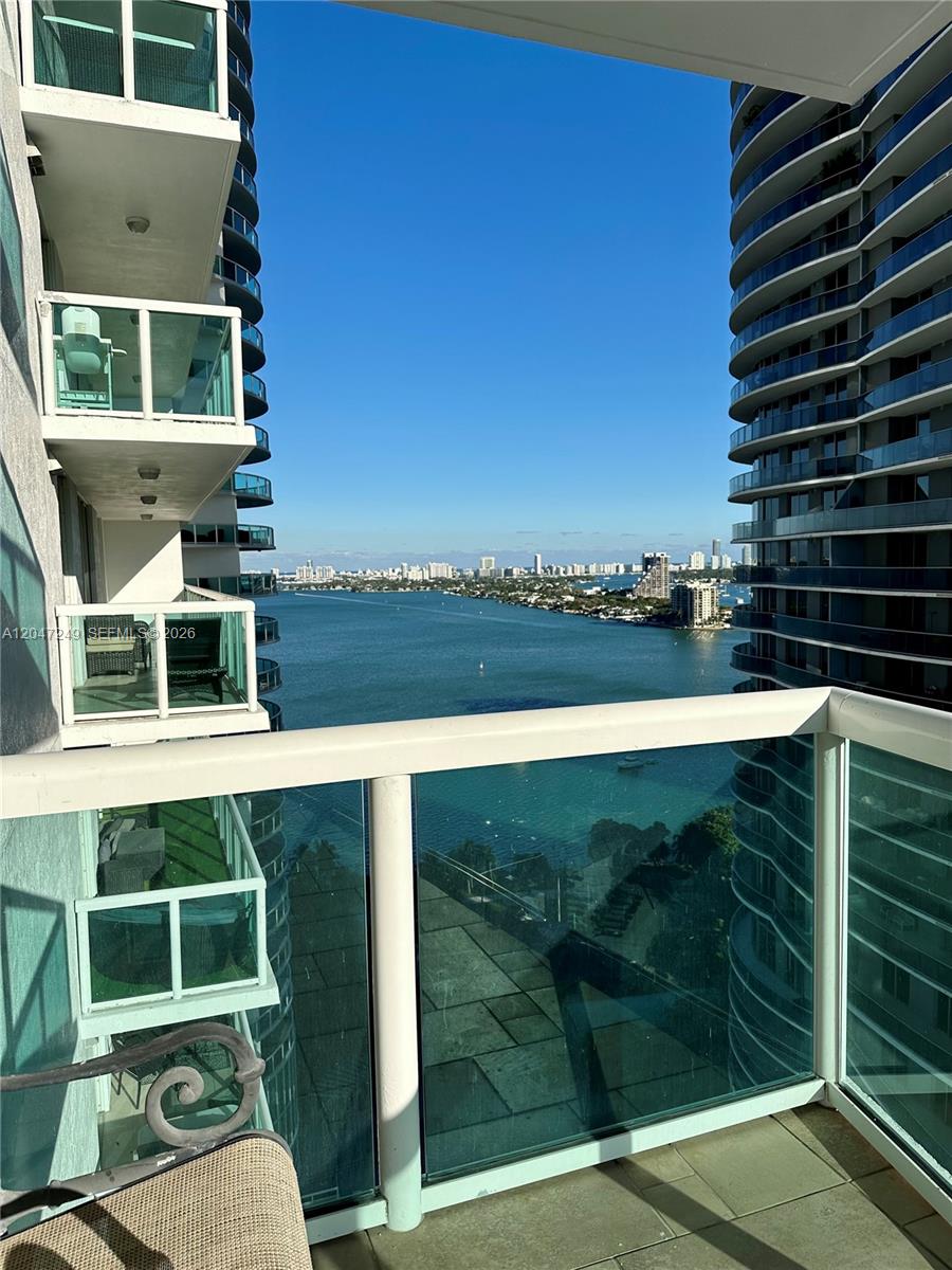 A high-rise balcony overlooks a bay with a distant city skyline under a clear sky — 1800 N Bayshore Dr # 2315, Miami FL 33132, MIAMI, FL