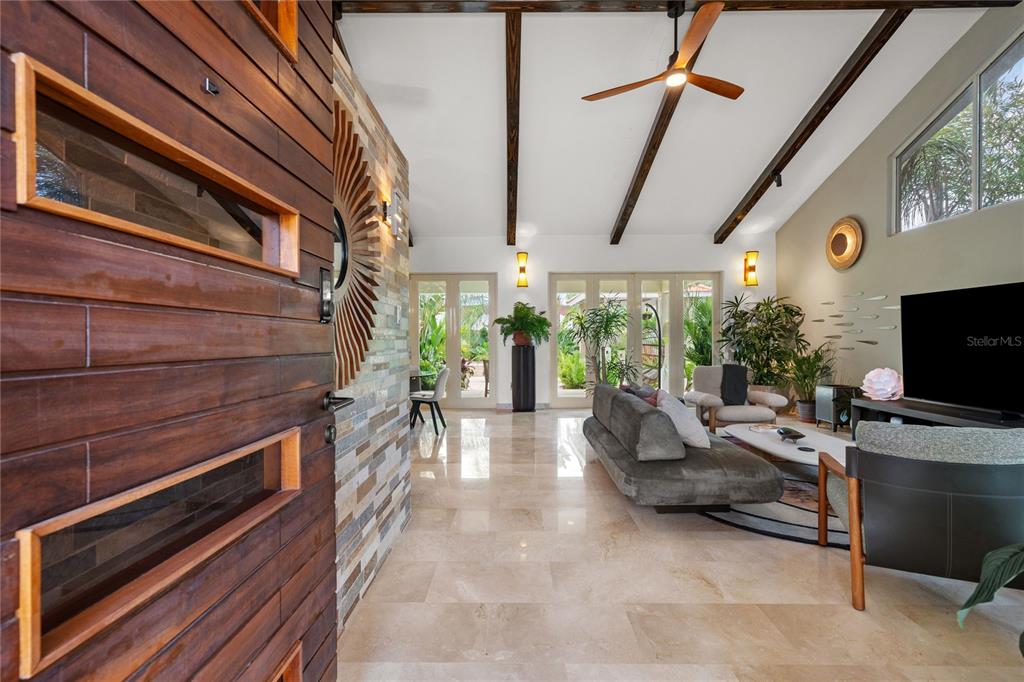 A modern living room features vaulted ceilings with exposed beams, tile flooring, and glass doors — 319 CAMINO DEL GUAMA, DORADO, PR