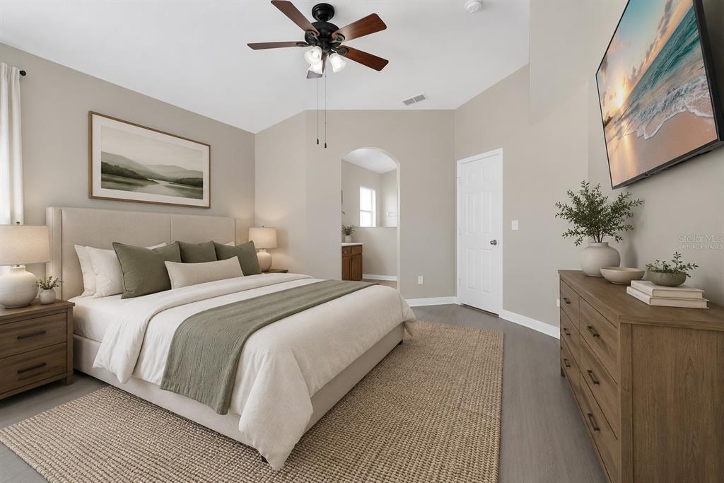 A bedroom features a bed with green accents, a wooden dresser, and a ceiling fan — 348 SIR PHILLIPS DRIVE, DAVENPORT, FL