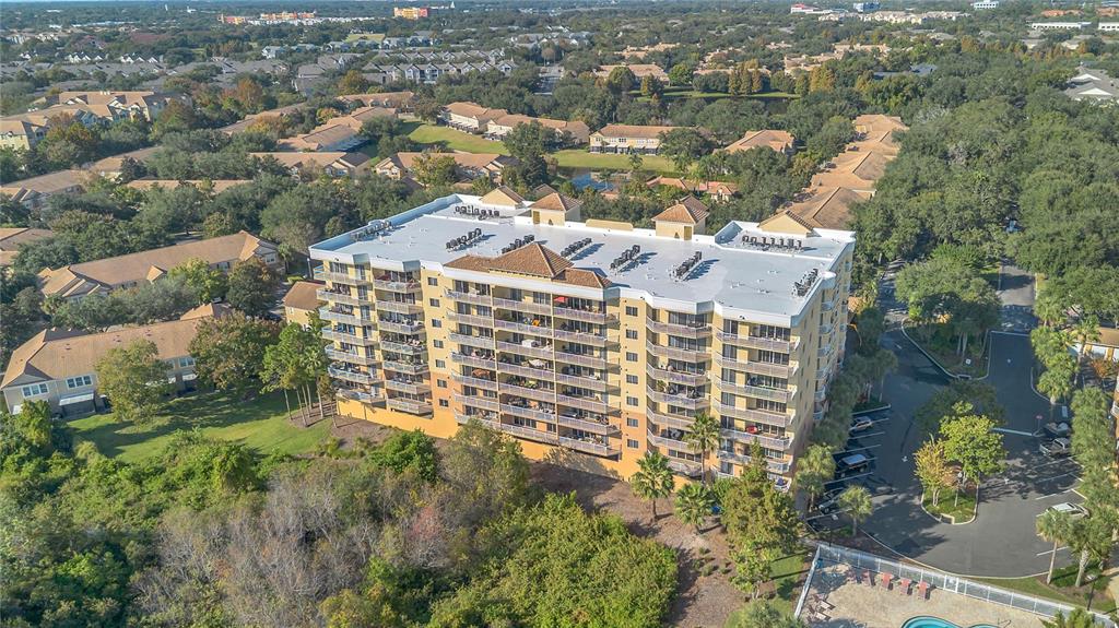 A living room with tile floors, a ceiling fan, and sliding glass doors overlooking water — 6336 BUFORD STREET UNIT 405, ORLANDO, FL