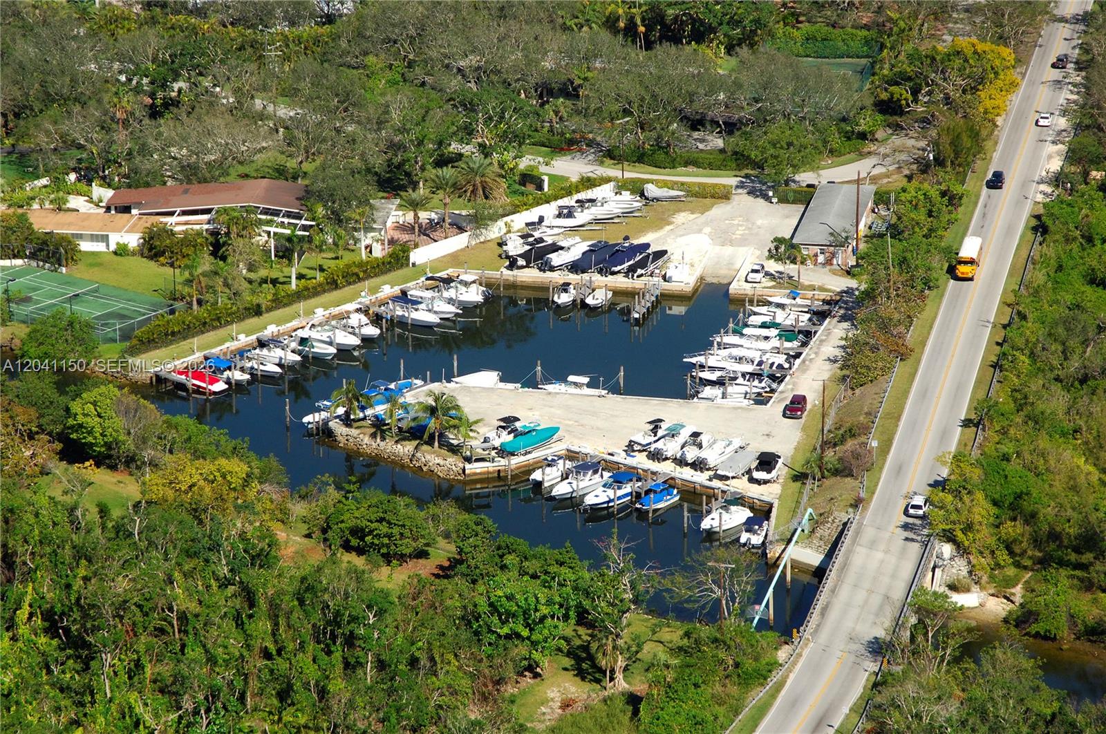 An aerial view shows a marina with numerous docked boats and a nearby road — 9979 Fairchild Way, Coral Gables FL 33156, CORAL GABLES, FL
