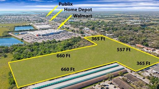 An aerial view shows a vacant, L-shaped plot of land outlined in yellow near retail stores — 1905 S. PARROTT AVE., Okeechobee FL 34974, OKEECHOBEE, FL