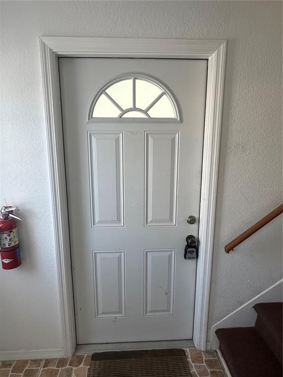 A white front door with a semi-circular window sits next to a wall-mounted fire extinguisher — 4158 TAMIAMI TRAIL UNIT B1, PORT CHARLOTTE, FL