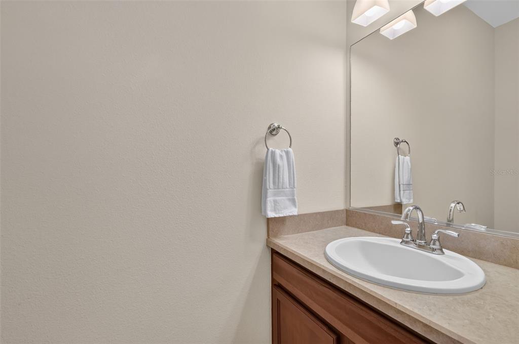 A bathroom features a vanity with a white sink, a mirror, and a towel ring — 2693 IRIS WAY, THE VILLAGES, FL