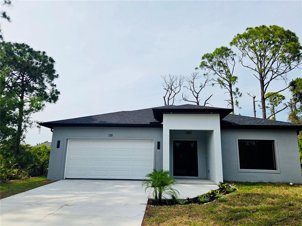 A single-story house with a gray exterior, white garage door, and a covered front entrance — 138 INGRAM BOULEVARD, ROTONDA WEST, FL