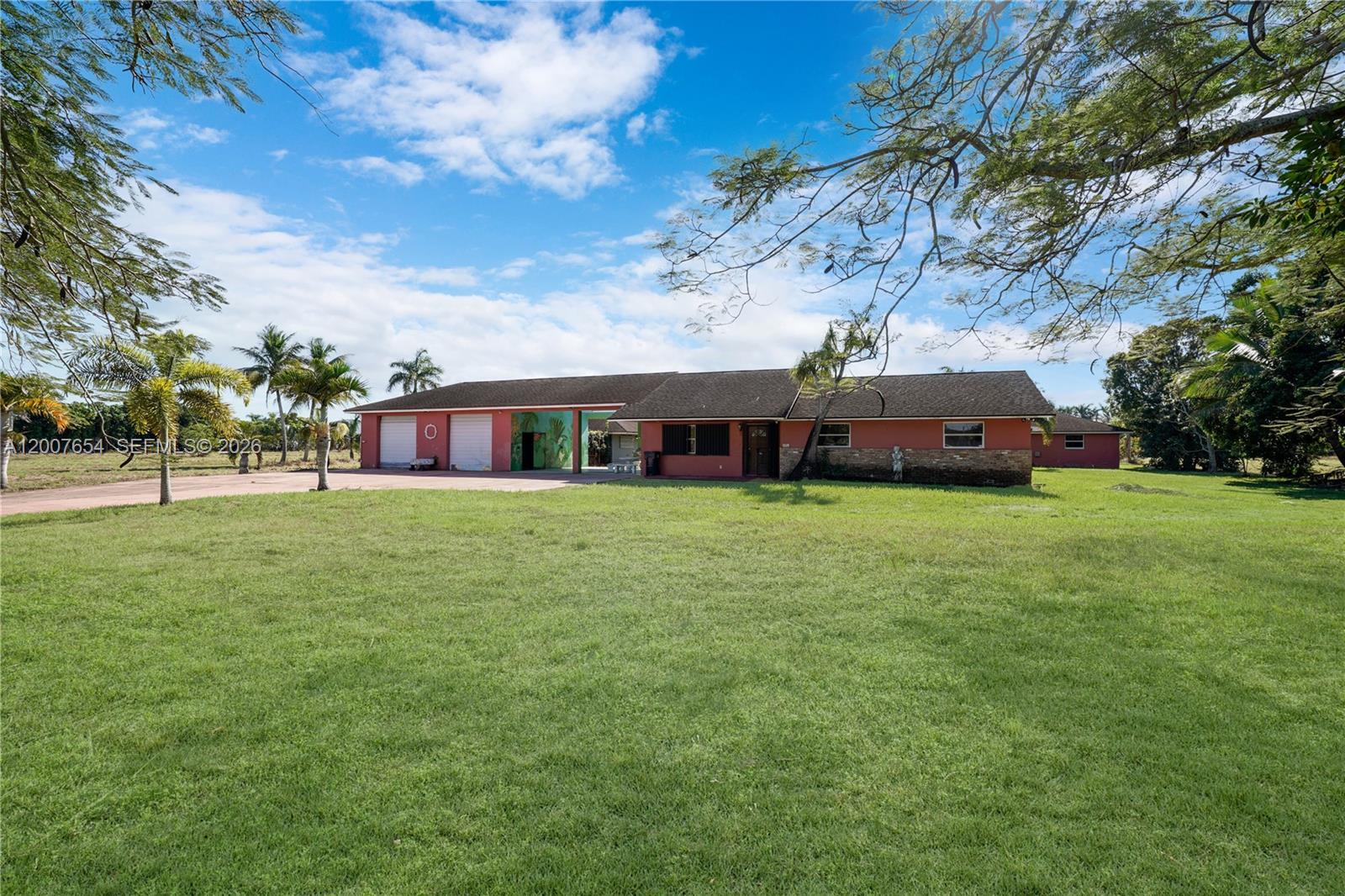 A single-story red house with an attached garage sits on a large grassy lot — 20000 SW 216th St, Miami FL 33170, MIAMI, FL